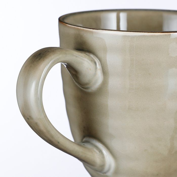 Nærbillede af hank på Tabo stentøjskrus i creme