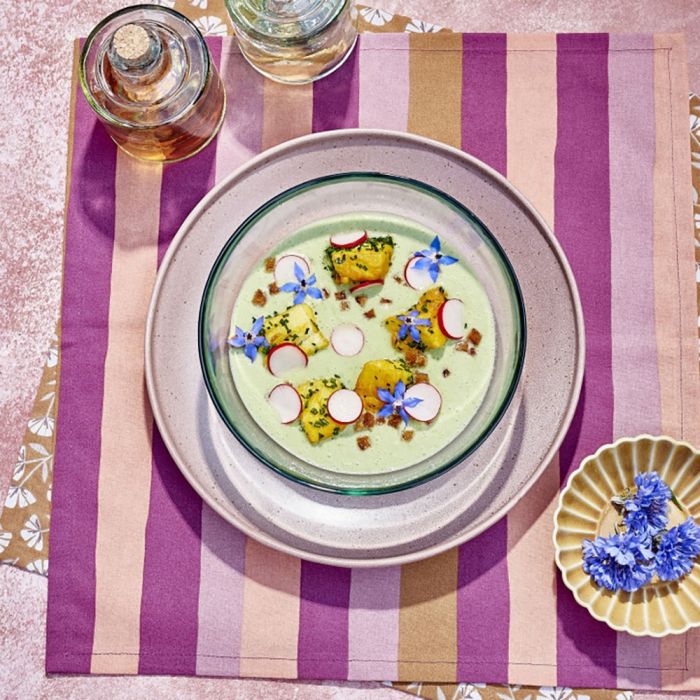 Pesca skål lille i okkerfarvet keramik med blå blomster på farverig dækkeserviet