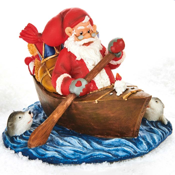 Julemanden ror kajak på en lille vandflage. Søde hoveder fra to sæler dukker op på hver side af båden, hvori der ligger gaver. Flotte detaljer fra Pobra.