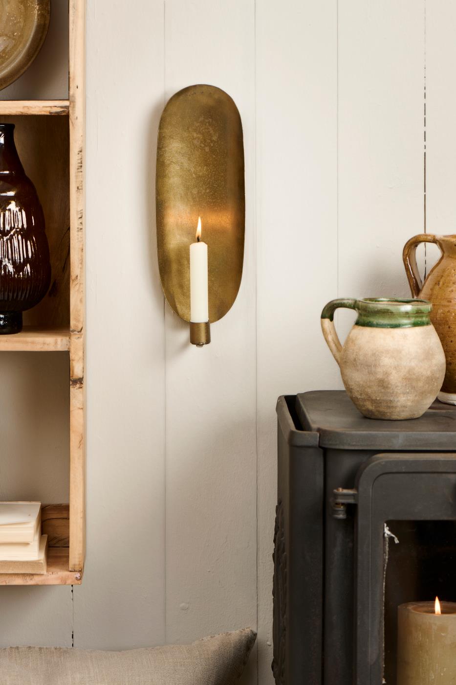 Väggljusstakar med ljus hänger på en vit vägg från Ib Laursen