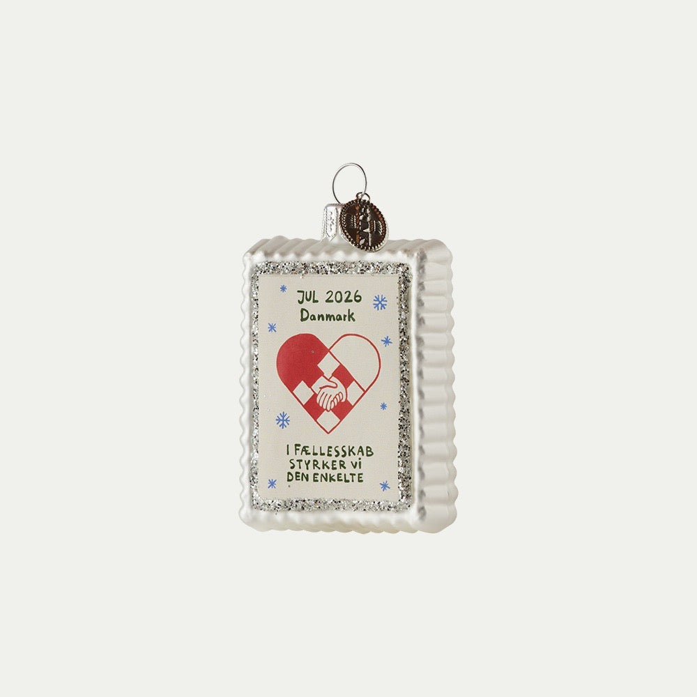 Julmärkesornament 2026 med flätat julhjärta, händer som håller varandra och silverfärgad glitterkant