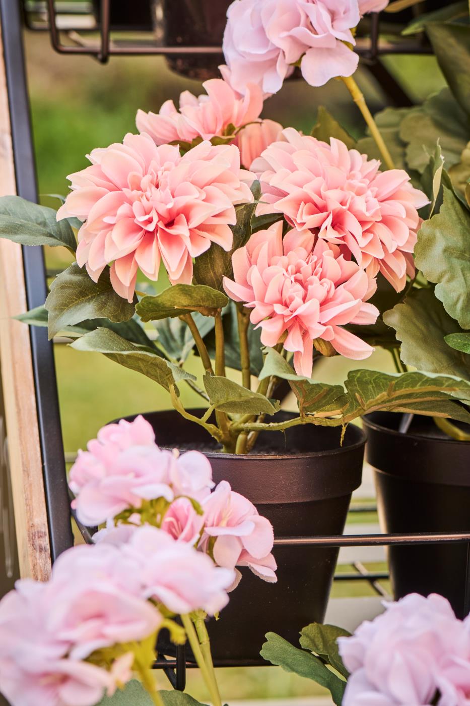 Kunstig rosa Dahlia i sort urtepotte i blomsterstavtiv