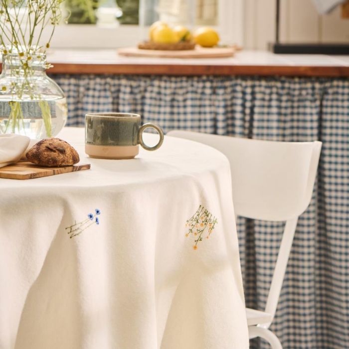 Ib Laursen Flora dug 150x250 butter cream med blomsterbroderi med kaffekop i køkken