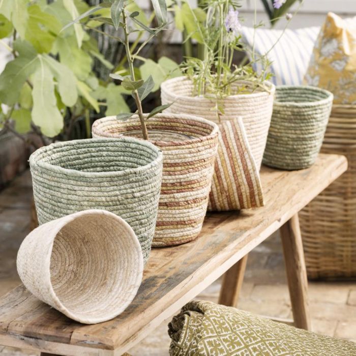 Ib Laursen dekorativ kurv/urtepotteskjuler i majsblade. Flere på en bænk