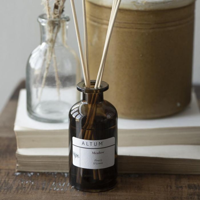 ALTUM Meadow duftpinde fra Ib Laursen i brun flaske foran bøger
