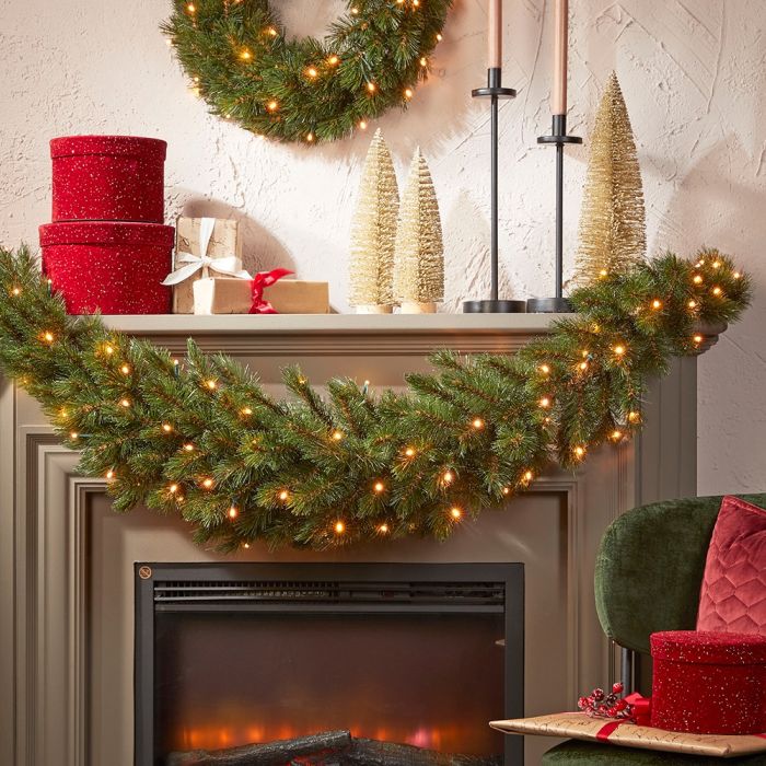 2 runde røde opbevaringskasser ovenpå pejs med julepynt