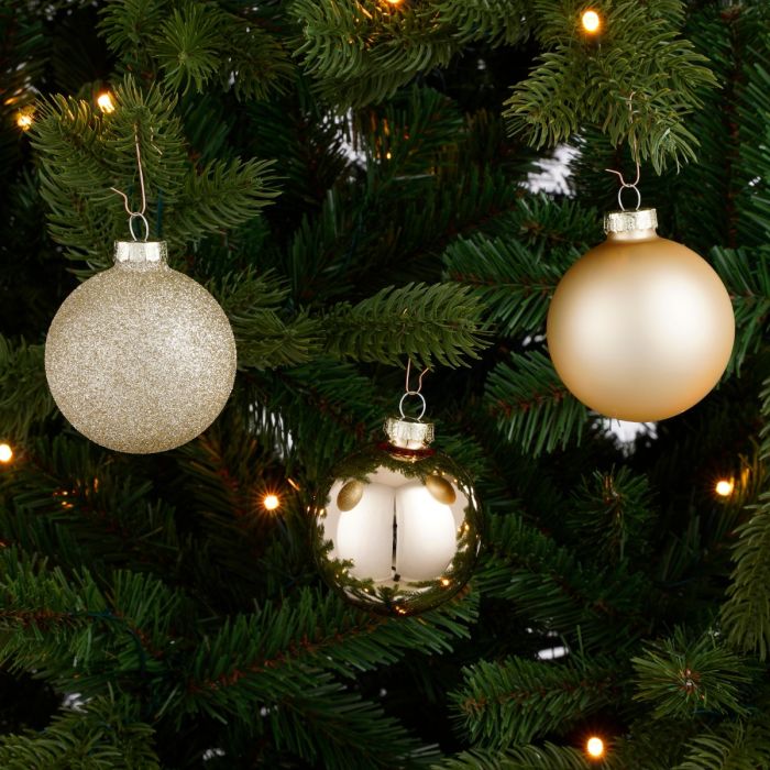 Julekugler i glas i champagnefarvet nuance. En blanding af glitter