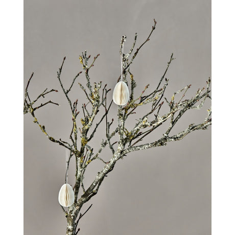 Påskeæg i honeycomb hænger på en grene med mos