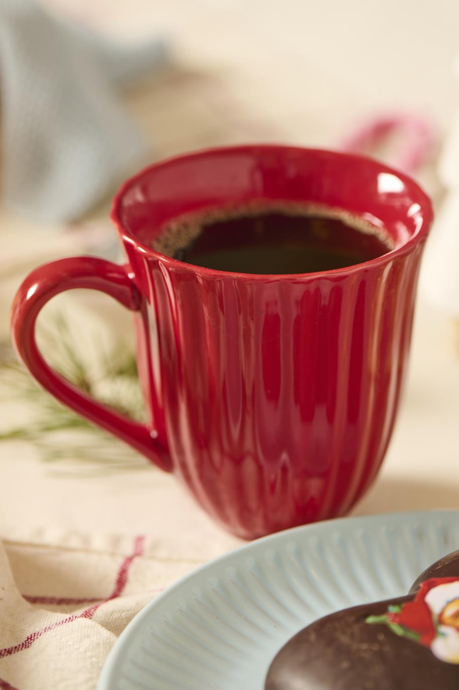 Räfflad mugg från Ib Laursens Mynte-serie i jordgubbsröd, fylld med kaffe