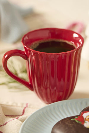 Räfflad mugg från Ib Laursens Mynte-serie i jordgubbsröd, fylld med kaffe