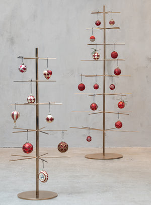 Julgranar i metall prydda med glasornament i röda nyanser från Speedtsberg