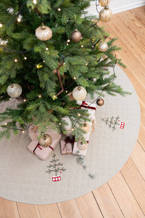 Pyntad julgran stående på en quiltad julgranskjol med broderi från Speedtsberg