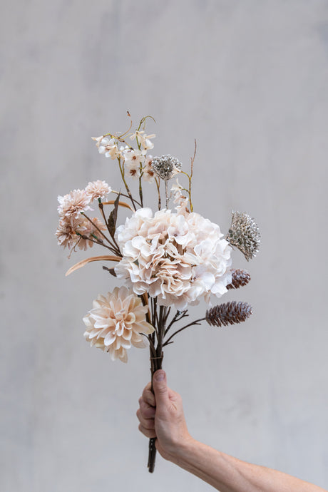 Bukett med konstgjorda rosa blommor och grenar med kottar och glitter från Speedtsberg
