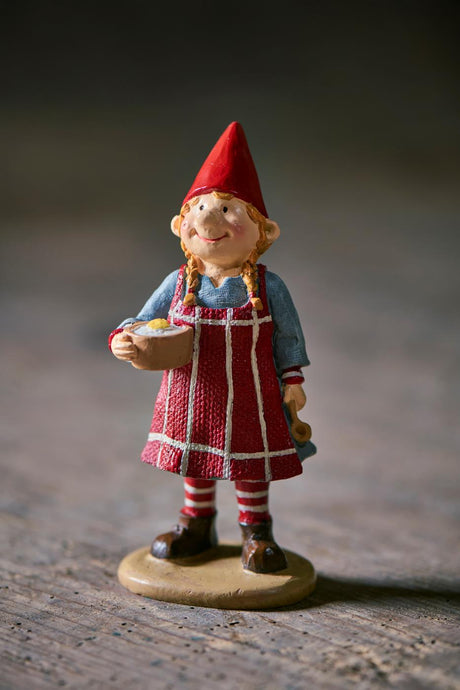 Ribbstickad tomte Agnes med risgrynsgröt, 14 cm hög, från Ib Laursen, stående på ett bord