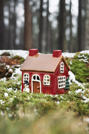 Stillenat Hus til fyrfadslys med snemand ved vinduet og to skorstene fra Ib Laursen stående i skoven