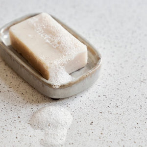 Meraki Datura sæbeholder i stentøj med sæbe liggende i