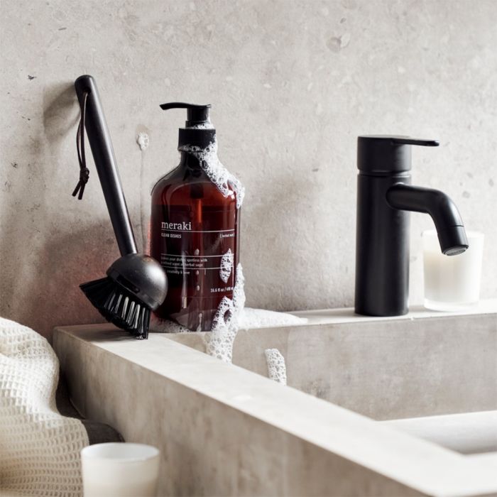 Opvaskemiddel og opvaskebørste fra Meraki stående ved vask