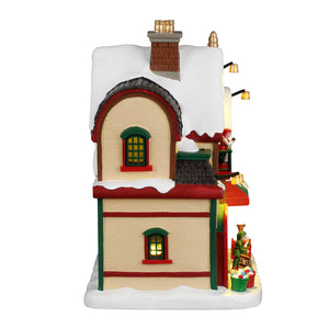 North Pole Christmas Supply hus med lys fra Lemax til juleby set fra siden med kvist med vindue