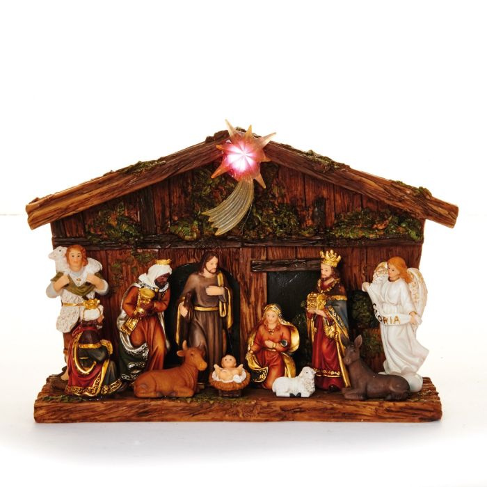 Krybbespil foran flot træagtig bygning med  stjerne på taget med lys i. Til stede er Josef og Jomfru Maria med det lille Jesus barn samt de 3 vise mænd, Kejser Augustus og en smuk engel. Fra Pobra.