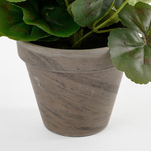 Grå lerpotteskjuler med en kunstig pelargonie i
