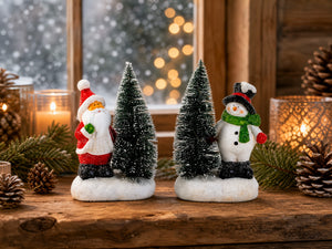 Jultomte eller snögubbe bredvid julgran med ljus