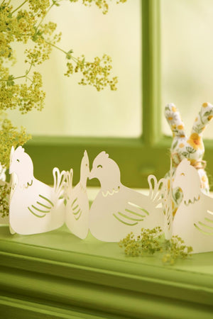 Påskebordpynt høns stående i grøn vindueskarm