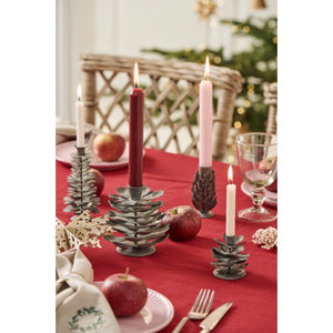 Juletræslys i koglestager på et juledækket bord