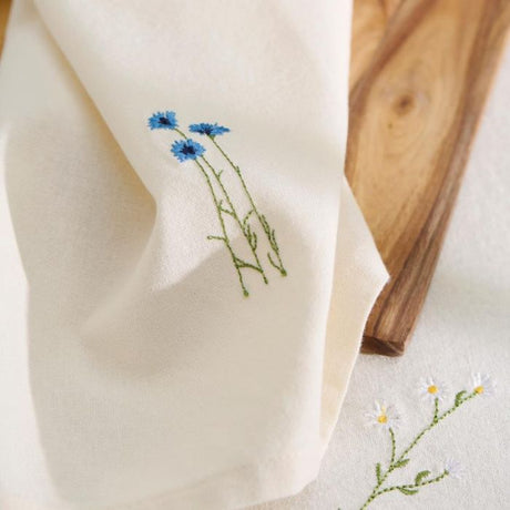 Ib Laursen Flora stofserviet – butter cream med kornblomst på træbræt på dug fra samme serie