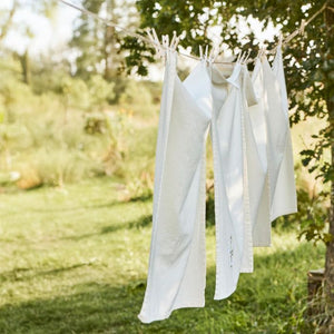 Ib Laursen Flora viskestykke med hvide margueritter hænger på tørresnor udendørs