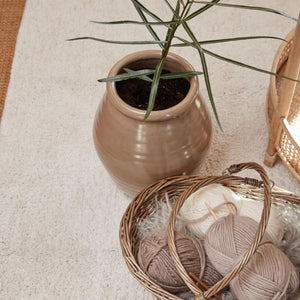 Ib Laursen opbevaringskurv i pil med to hanke med strikketøj på gulv med stor vase set fra oven