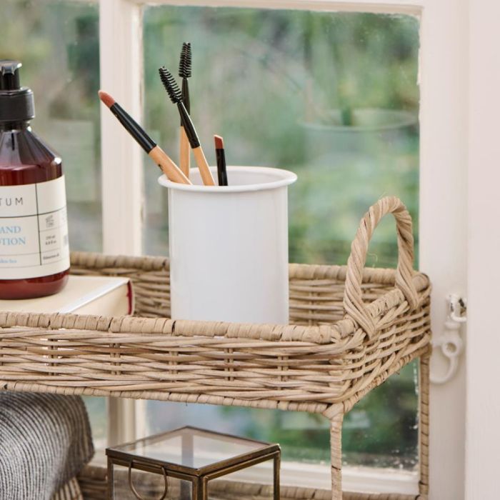 Flettet rattanbakke i to etager fra Ib Laursen i vindueskarm med makeup pensler i hvid krukke