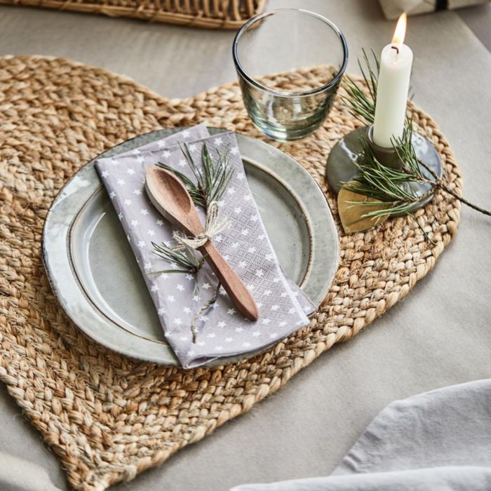 Hjerteformet dækkeserviet i jute fra Ib Laursen med opdækning med gran og levende lys